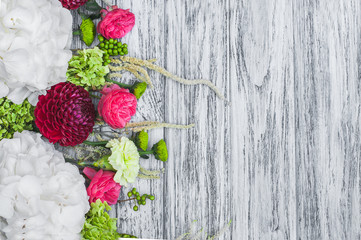 Flowers frame on white wooden background. flower ornament with rose, dahlia, hortensia and carnation flowers. Red and green. Top view with copy space