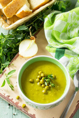 Diet menu. Puree soup with green pea in a bowl on a kitchen wooden table. The concept of healthy eating.