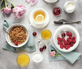 Breakfast table setting with granola and fresh raspberries. Overhead view