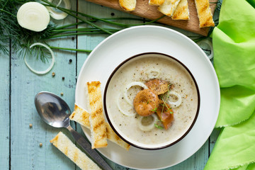 Puree soup mushrooms with croutons in a bowl on a kitchen wooden table. The concept of healthy eating.  Diet menu. Top view with copy space.