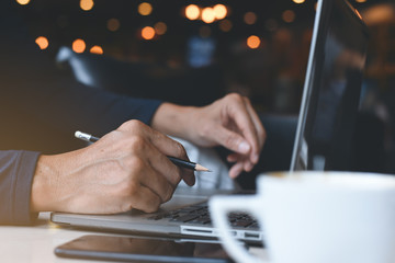 Man working on laptop computer and smart phone