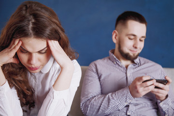 Difference between hobbies and interest conflict concept. A young depressed woman quarreles with her husband playing video games.