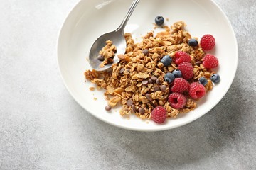 Granola. Healthy breakfast with granola and seasonal berries. Gray concrete background