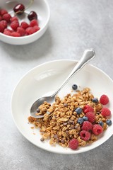 Granola. Healthy breakfast with granola and seasonal berries. Gray concrete background