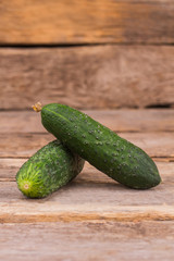 Two cucumbers on table. Close up. Wooden table background.
