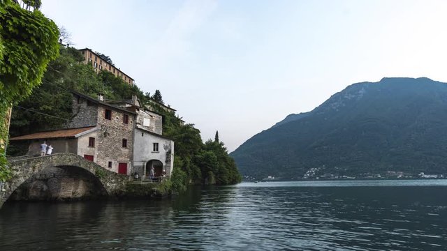 day to night time lapse of nesso a small village over the river of como lake with alps