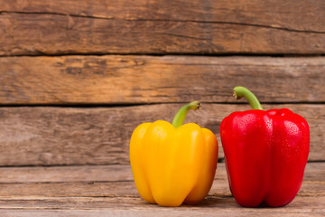 Healthy colorful bell peppers on wooden background. Yellow and red. Old rustic wood background.