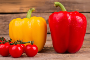 Collection of vegetables on wooden background. Bulgarian bell peppers and tomatoes with dew.