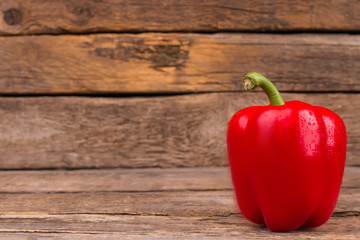 Organic Red Capsicum. Wooden table background wih copyspace.
