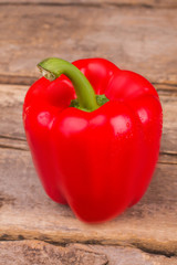 Colorful healthy appetizing red bell pepper. Close up. Old rustic wooden desk background.