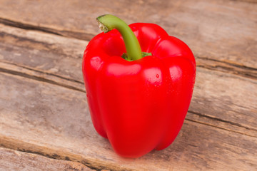Fresh, sweet, red bell pepper. Old rustic wooden table background.