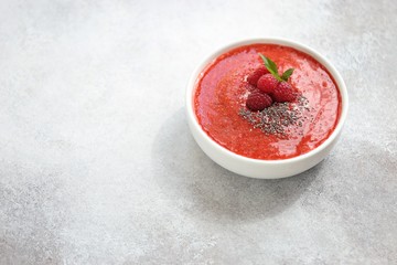 Smoothie bowl. Berrie smothie with chia seeds and raspberry topping. Super food, clean eating, plant based concept. Copy space