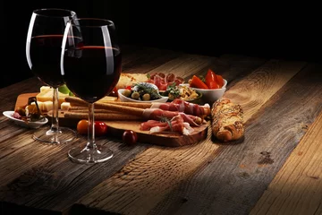 Rolgordijnen Italiaanse antipasti wijn snacks set. Kaasvariëteit, mediterrane olijven, crudo, Prosciutto di Parma, salami en wijn in glazen over houten grungeachtergrond. © beats_