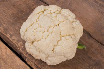 White cauliflower on wood. Close up, Top view. Rustic wooden table background.
