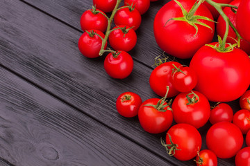 Fresh tomatoes and cherry tomatoes on wood. Top view. Free space for space.