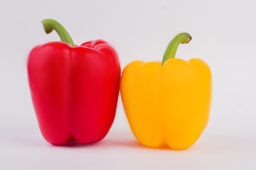 Two paprika vegetables. Red and yellow bell peppers over white background.