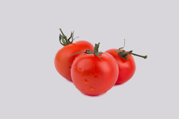 Red shiny tomatoes with water drops. White isolated background, cut out.