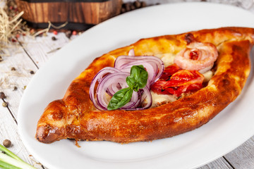 Traditional Georgian and Armenian cuisine. Khachapuri with suluguni cheese and egg yolk. background image. Copy space, selective focus