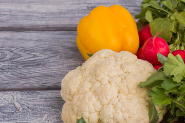 Organic bell pepper, cauliflower and radish. Close up. Wooden surface backgorund.