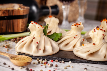 Traditional Georgian and Armenian cuisine. Georgian khinkali with a cherry on a white plate, on a...