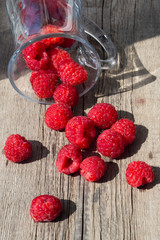Raspberry is scattered on a wooden surface.