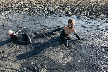 Grandfather with grandson in healing mud