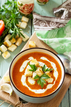 Puree soup tomato with croutons and cream in a bowl on on a kitchen wooden table. The concept of healthy eating. Diet menu. Copy space.