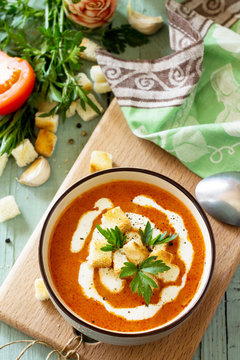 Diet menu. Puree soup tomato with croutons and cream in a bowl on a kitchen wooden table. The concept of healthy eating.