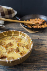 Caraway soup with croutons on rustic wooden table