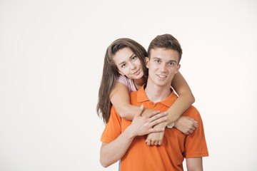 Happy lovely couple hugging and smiling looking at camera on white background