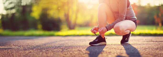 Young woman running in the park. Active person outdoors at the dusk in summer - obrazy, fototapety, plakaty