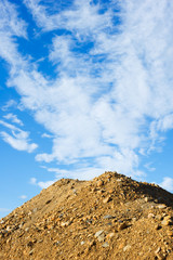 Heap of sand and gravel against sky.