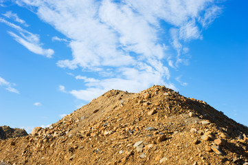 Heap of sand and gravel against sky.