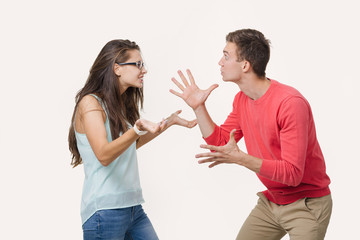 Angry couple arguing screaming to each other. Studio shot on white background. Discord in the relationship. Divergence of points of view