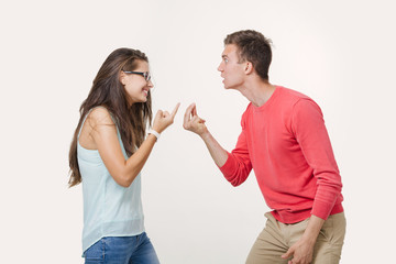 Angry couple arguing screaming to each other. Studio shot on white background. Discord in the relationship. Divergence of points of view