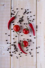 Red pepper tomatoes garlic parsley on a white wooden background.