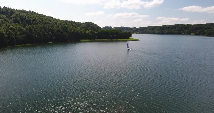 Aerial: Sailboat On Blue Forest Lake