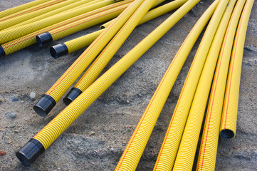 Yellow plastic pipes in the sand.