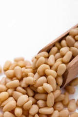 peeled pine nuts on a white acrylic background