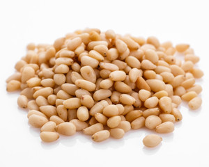 peeled pine nuts on a white acrylic background