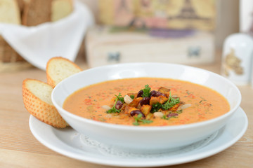 pumpkin soup with beans and croutons on a white plate