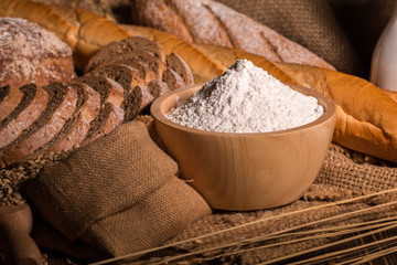 Whole wheat bread,flour and cloth bag on wood table.Copy space.