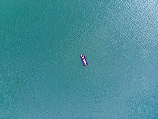 woman on mattress in azure water. overhead view. copy space