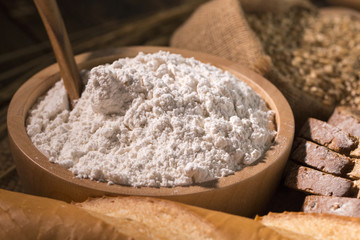 Whole wheat bread,flour blow and oat on wood table.Copy space.