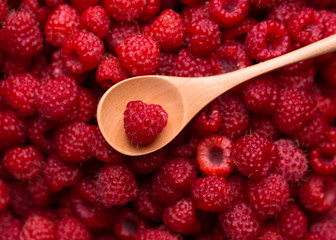 Fresh raspberries and a wooden spoon