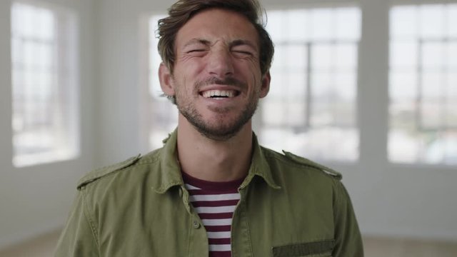 close up portrait of attractive young man laughing cheerful enjoying lifestyle happy caucasian guy in apartment background