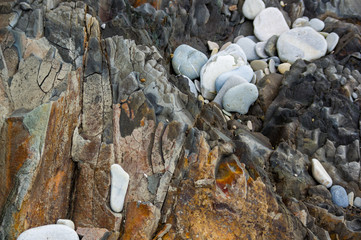 pebble stones on the sea beach, the rolling waves of the sea with foam