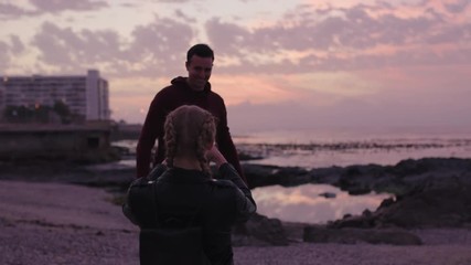 young couple having fun taking photo on beach man posing arms raised happy cheerful - Powered by Adobe