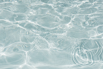 Pattern of blue water surface in swimming pool, Ripple wave and motion water for blue background and abstract, Bright and purified water with sun reflection in pool