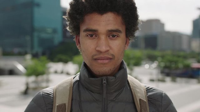 portrait of handsome young mixed race man unhappy worried looking at camera sad in urban city background
